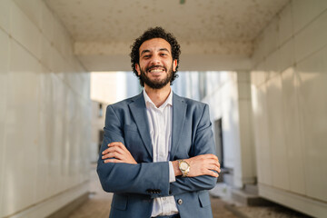 Smiling businessman with crossed arms in modern office building