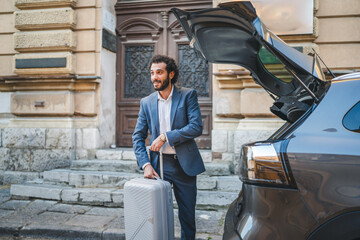 Businessman loading luggage into car trunk on city street © Miljan Živković