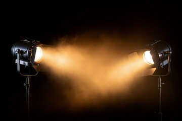 Two stage spotlights cutting through smoke with dramatic beams on a dark background, theatrical atmosphere, Generative AI