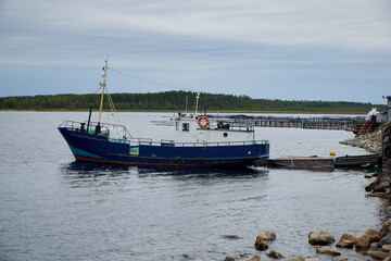 Fototapeta premium A Fishing Boat is peacefully moored at the dock on a lovely and calm day by the sea