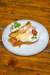 Delicious gourmet dessert with caramelized banana, whipped cream, and fresh fruit on a plate