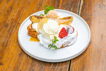 Delectable dessert with bananas, strawberries, and ice cream on a white plate, a sweet treat