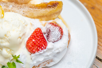 Delicious pancake with fresh strawberries, whipped cream, and caramelized banana dessert