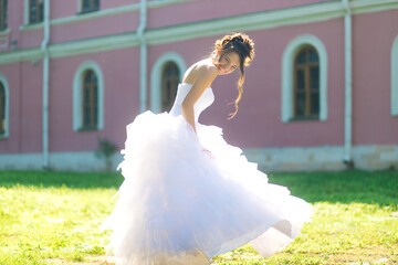 Laughing Bride Twirling in Wedding Dress in Summer Park, Joyful and Dynamic Bridal Portrait with...