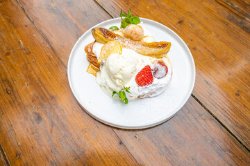 Delicious gourmet dessert with ice cream, caramelized bananas, and fresh berries on a plate