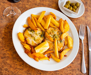 Appetizing grilled hake fillet with potatoes and spices