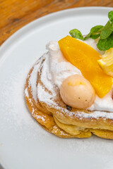 Delicious pastry dessert with fresh fruits and powdered sugar on a white plate, gourmet food