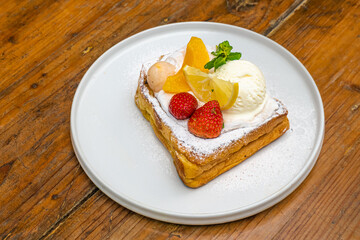 Delicious gourmet dessert with fresh fruit and ice cream on a white plate, food photography