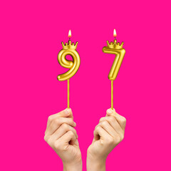 Hands holding number shaped candles - Birthday number 97