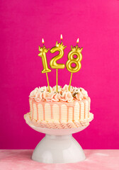 Number 128 birthday candle - Pink celebration cake with drip icing