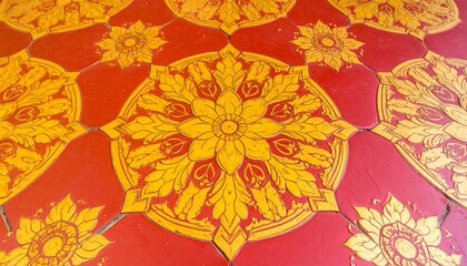 A detailed view of ornate, decorative floor tiles featuring symmetrical floral patterns in vibrant red and gold.