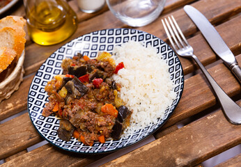 Appetizing stewed eggplants with minced meat served with rice garnish