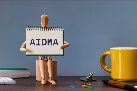 There is notebook with the word AIDMA. It is an abbreviation for Attention, Interest, Desire, Memory, Action as eye-catching image.
