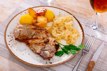 Delicious fried pork with pickled cabbage and potatoes served on platter
