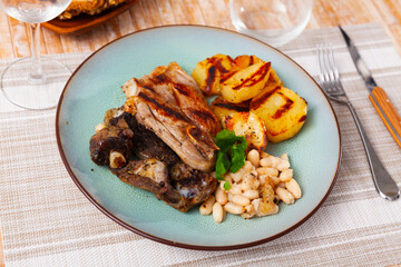Appetizing lamb stew with boiled potatoes and white beans closeup