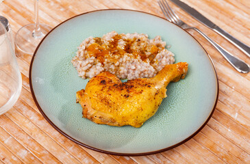 Appetizing pieces of fried chicken with buckwheat on platter