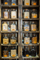Various nuts and dried fruits neatly arranged in jars on shelves