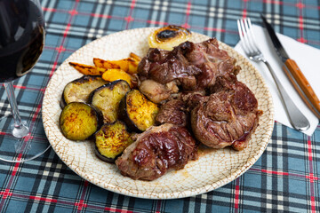 Serving of grilled beef with potatoes and eggplant on side