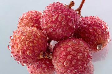 Fresh lychee fruits with water droplets on a white background, close-up shot