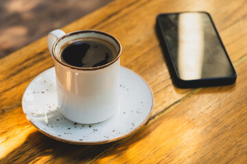Morning Coffee and Smartphone on Desk. Cup of Coffee and Smartphone on Wooden Table. Coffee Break with Mobile Phone.