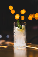 Glass with mint, lime and ice ready for cocktail. Fresh mojito preparation with lime and mint. Iced glass with lime and fresh mint leaves. Refreshing drink preparation with mint and lime.