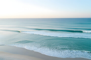 Obraz premium Serene ocean waves gently rolling onto a sandy beach