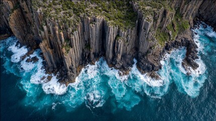 Aerial view of basalt cliffs and crashing waves in Tasmania, raw nature in dramatic coastal harmony.