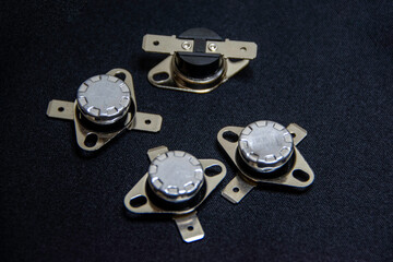 Photograph of bimetallic thermostats, an automatic electrical component used to detect temperature, commonly applied in appliances such as water dispensers, refrigerators, rice cookers, and microwaves