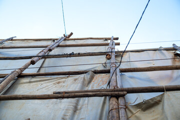 足場丸太を番線で固定して遮蔽シートを掛けた様子