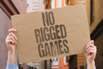 “No Rigged Games” appears on a cardboard protest banner demanding fairness and equality in sports. JUSTICE. UNITY. HONESTY. EQUALITY. RIGHTS. VOICE. SOLIDARITY.