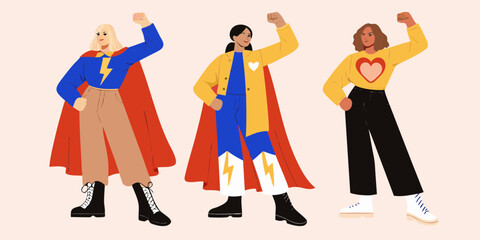 Three diverse women in superhero capes and bold outfits striking powerful poses celebrating strength and unity