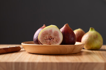 Fresh fig on wooden plate and cutting wooden board with black background, Autumn fruit