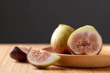 Fresh fig on wooden plate with black background, Autumn fruit
