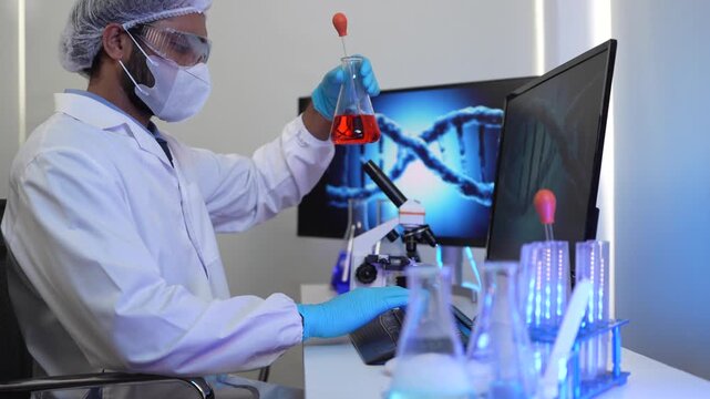 A geneticist performs microscopic analysis of a cellular sample, cross-referencing observations with genomic data displayed on a bioinformatics workstation in a biotech lab.