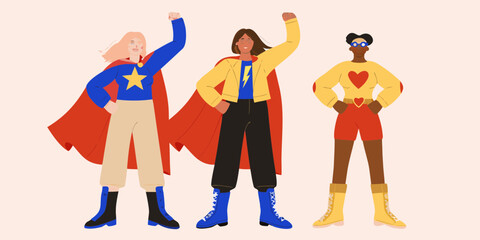 Three diverse women in superhero costumes with capes and boots striking a confident pose