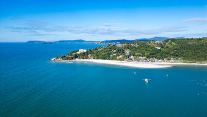 Fototapeta premium Aerial view of Jurerê Beach in Florianópolis, Santa Catarina, Brazil, showing turquoise sea, sandy shore and urban area by the coast