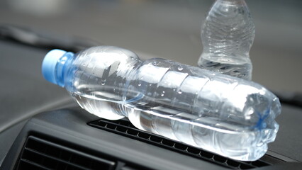 The bottle in the car that is exposed to the sun.
