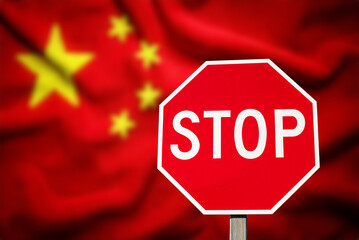 A stop sign in front of the Chinese flag