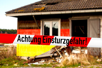 Deutsche Flagge und ein marodes, baufälliges Haus als Symbol für den Zerfall Deutschlands