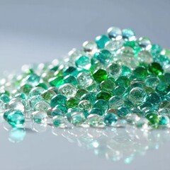 A pile of translucent green glass beads, reflecting light on a smooth surface