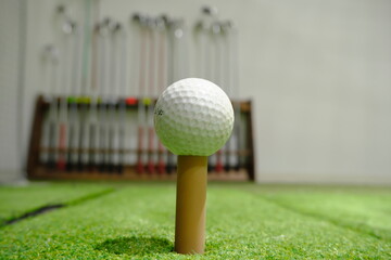 A Golf Ball in Focus with a Rack of Clubs in the Blurred Background
