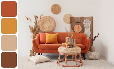 Interior of light living room with autumn decor and orange sofa. Different color patterns