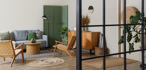 Interior of modern living room with grey sofa, armchairs and coffee table