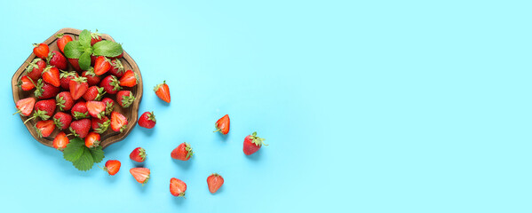 Wooden board and sweet strawberries on light blue background with space for text, top view