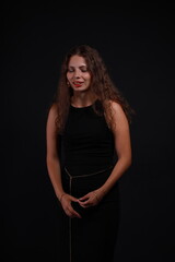 Fototapeta premium Low key portrait of pretty brunette woman in black dress