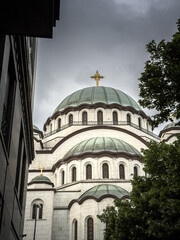 A low-angle view of the monumental Saint Sava Temple (Hram Svetog Save) in Belgrade Serbia beneath storm clouds. This orthodox church is the main monuments of serbian capital city of Belgrade