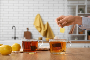 Brewing of black tea in glass cup on table in kitchen