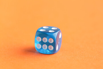 Blue game dice on orange background