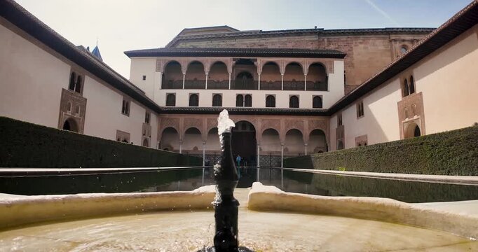Static close-up shot of the fountain with a view of the south fa&ccedil;ade of the Patio de los Arrayanes in the monumental complex of the Alhambra in Granada, Spain