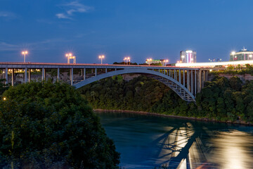 Rainbow Bridge at night illuminated with city lights, view from Canadian side, Niagara Falls